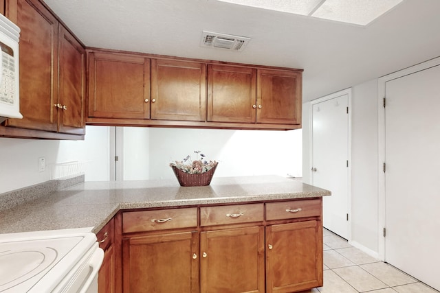 kitchen featuring white range and light tile patterned floors