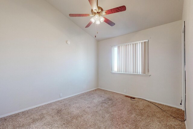 empty room featuring ceiling fan, lofted ceiling, and carpet