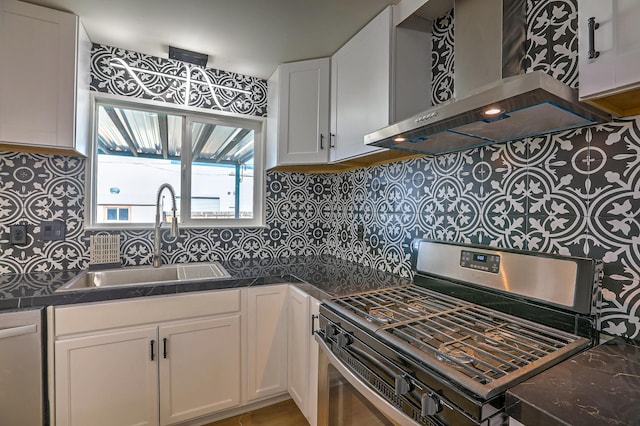 kitchen with appliances with stainless steel finishes, white cabinetry, sink, decorative backsplash, and wall chimney exhaust hood