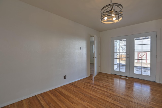 interior space featuring an inviting chandelier, hardwood / wood-style floors, and french doors