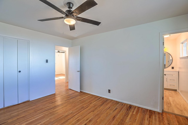 unfurnished bedroom featuring light hardwood / wood-style flooring, a closet, ceiling fan, and ensuite bathroom