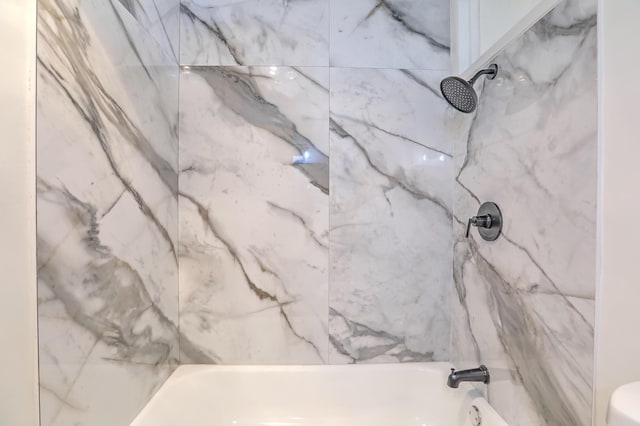 bathroom featuring tiled shower / bath