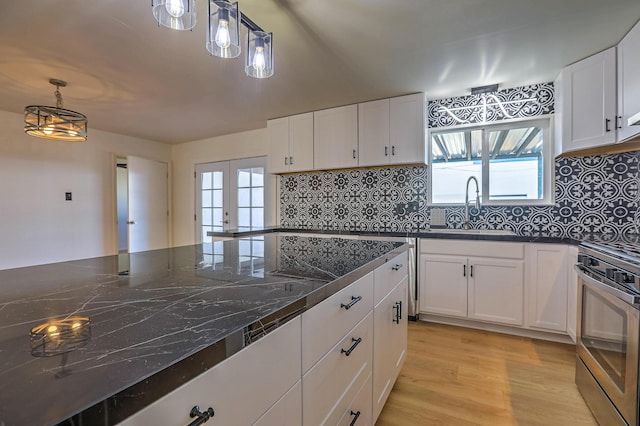 kitchen with pendant lighting, oven, sink, and white cabinets