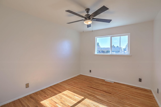 empty room with ceiling fan and light hardwood / wood-style flooring