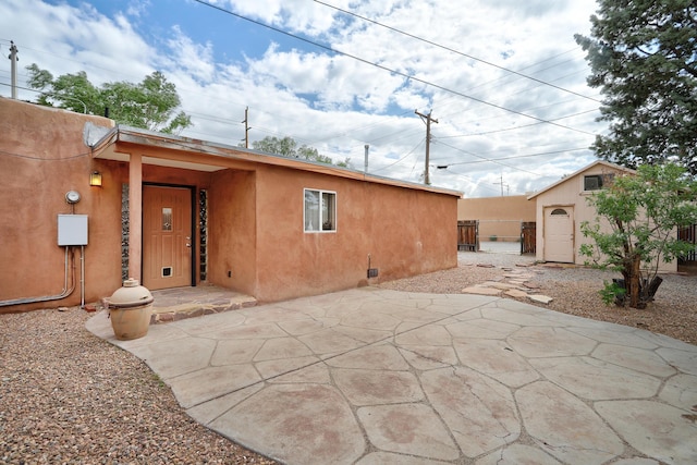 rear view of property with a patio and an outdoor structure