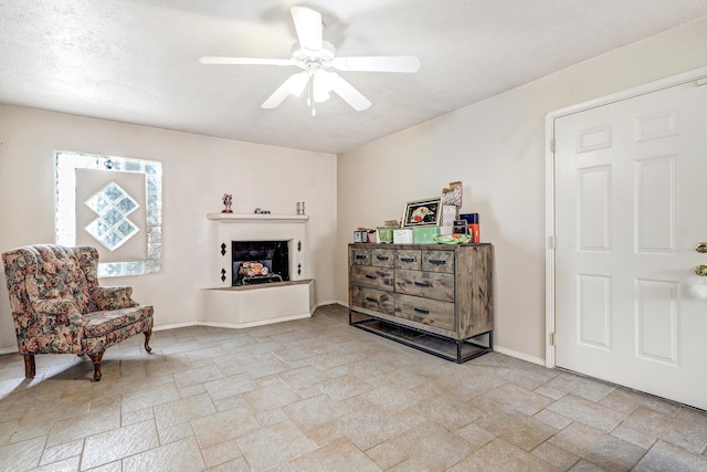 sitting room featuring ceiling fan and a textured ceiling