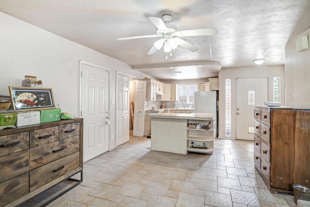 kitchen with ceiling fan, a textured ceiling, and white refrigerator