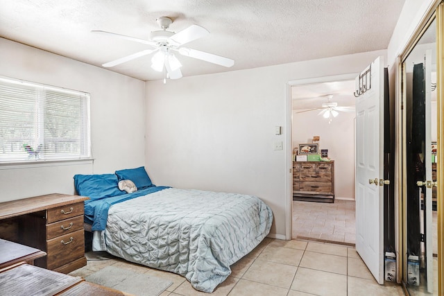 tiled bedroom with a textured ceiling and ceiling fan