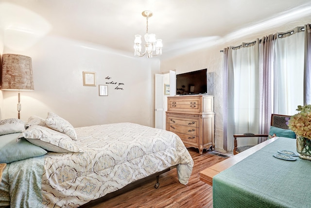 bedroom with wood-type flooring and a chandelier