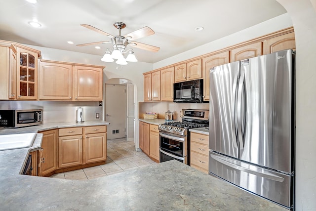 kitchen featuring sink, light tile patterned floors, light brown cabinets, ceiling fan, and black appliances