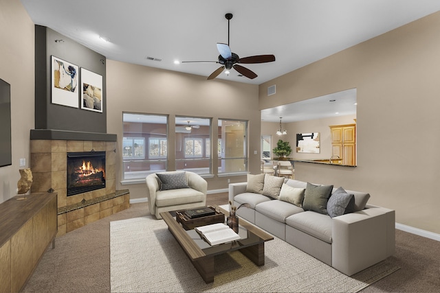 carpeted living room featuring a tile fireplace and ceiling fan