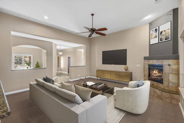 living room featuring ceiling fan, carpet, and a fireplace