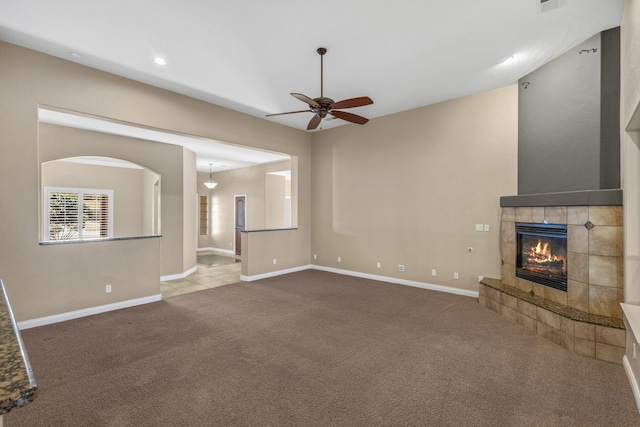 unfurnished living room featuring ceiling fan, a fireplace, and carpet floors