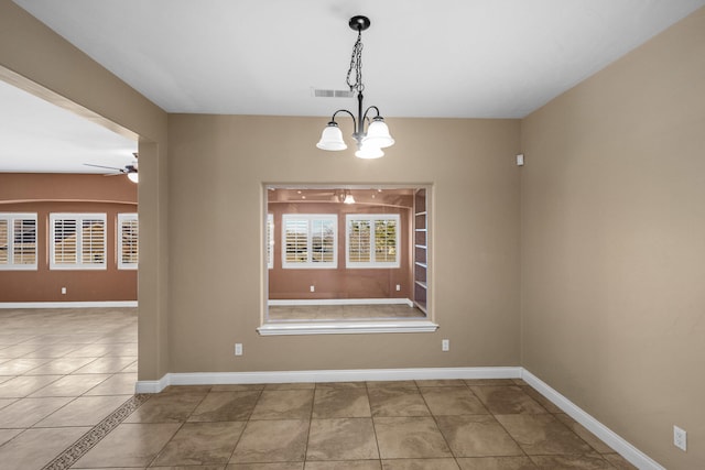 unfurnished dining area featuring ceiling fan with notable chandelier and tile patterned floors