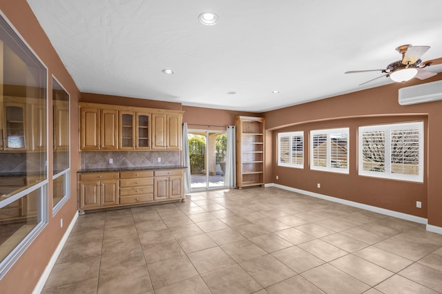 kitchen with tasteful backsplash, an AC wall unit, ceiling fan, and light tile patterned floors