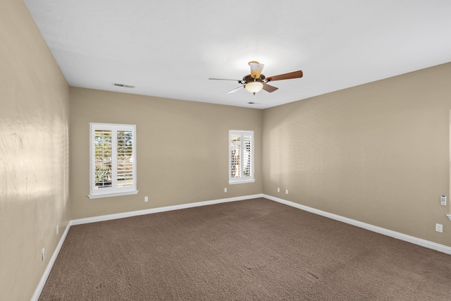 empty room featuring ceiling fan, plenty of natural light, and carpet