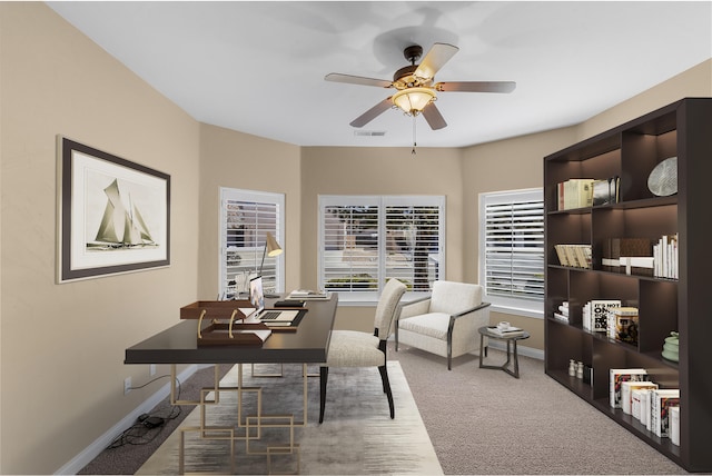 carpeted office space with ceiling fan