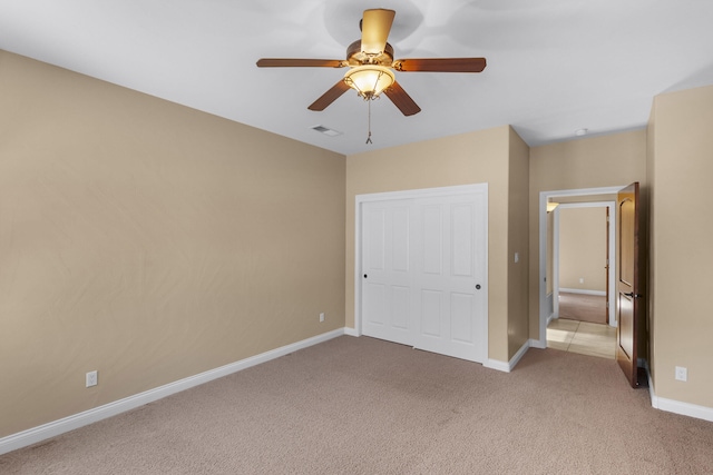 unfurnished bedroom with light carpet, a closet, and ceiling fan