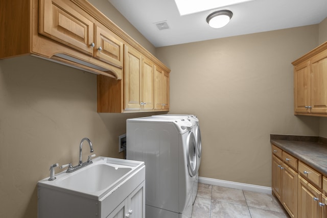 laundry room with cabinets, sink, washer and dryer, and light tile patterned floors