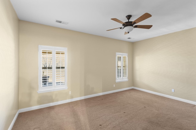 empty room featuring ceiling fan and carpet