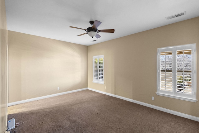 carpeted empty room featuring ceiling fan and plenty of natural light