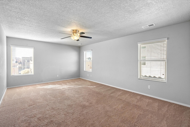 spare room featuring light colored carpet, a textured ceiling, and ceiling fan