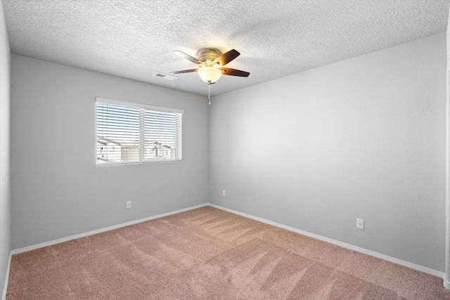 carpeted spare room featuring a textured ceiling and ceiling fan