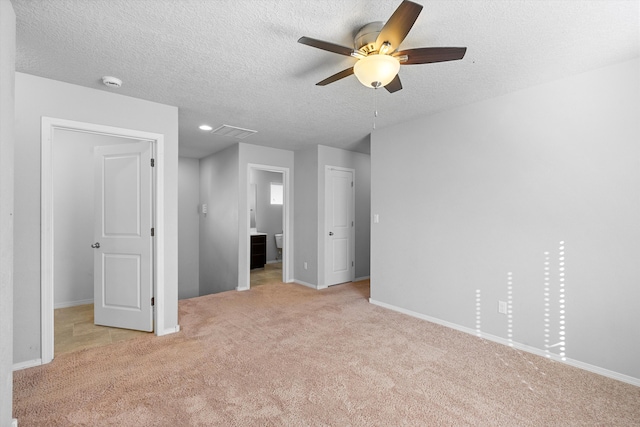 unfurnished bedroom featuring a textured ceiling, light colored carpet, and ceiling fan