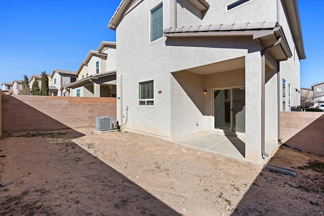 rear view of house with central AC unit and a patio area