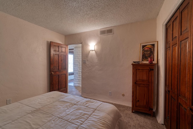 bedroom with a closet, light carpet, and a textured ceiling