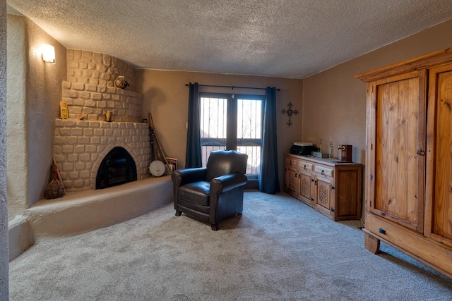 living area with light colored carpet, a fireplace, and a textured ceiling