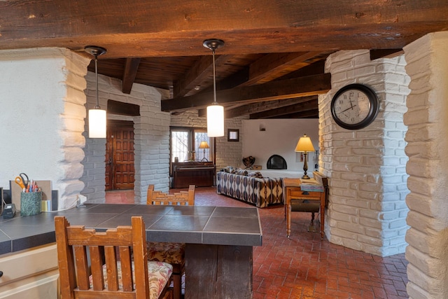 dining room featuring wood ceiling, beamed ceiling, and brick wall