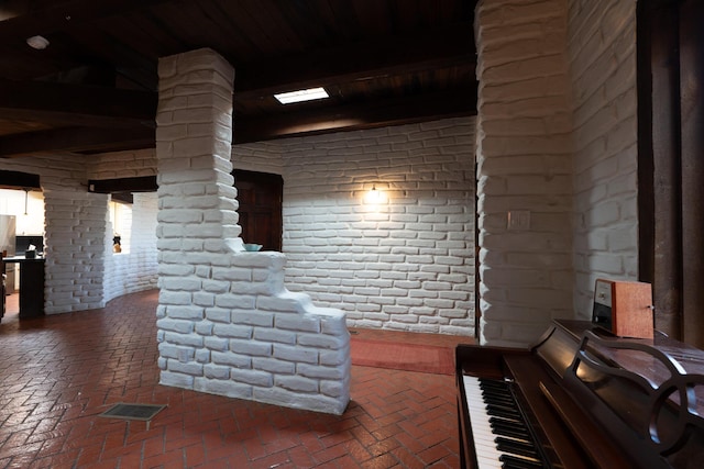 interior space with wood ceiling and brick wall