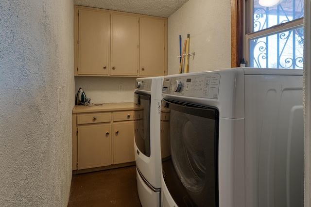 clothes washing area with cabinets, washer and dryer, and a textured ceiling