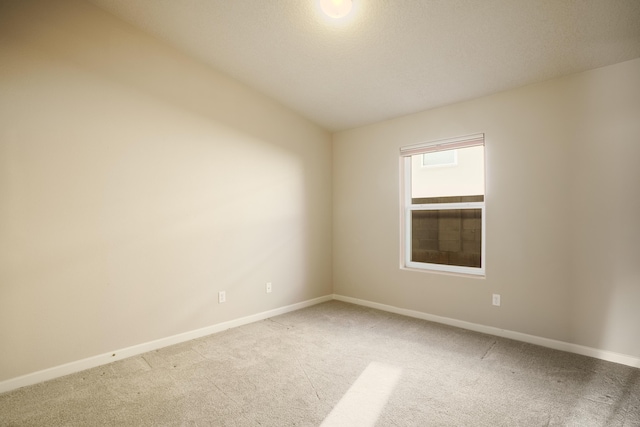 carpeted spare room featuring baseboards