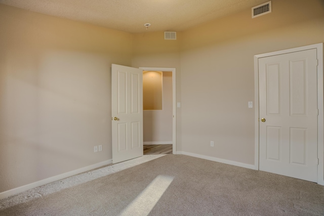 unfurnished room featuring baseboards, visible vents, and carpet flooring