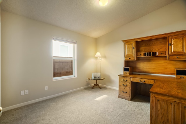 home office featuring light carpet, vaulted ceiling, a textured ceiling, and baseboards