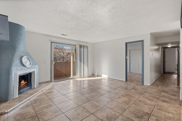 unfurnished living room with light tile patterned floors and a textured ceiling