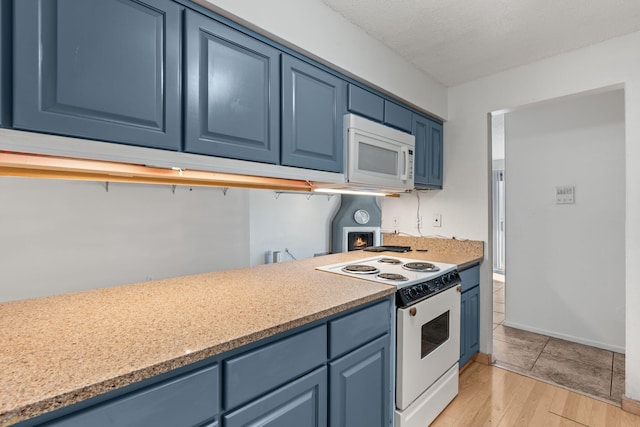 kitchen with blue cabinetry, white appliances, and light wood-type flooring