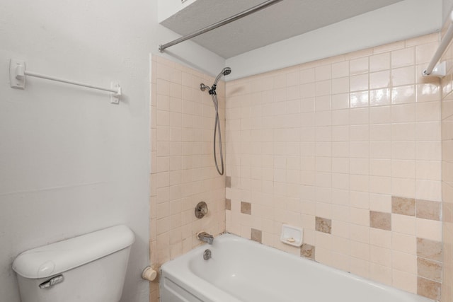 bathroom featuring toilet and tiled shower / bath