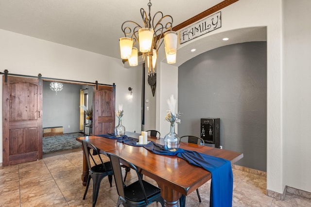 dining space featuring a barn door and an inviting chandelier