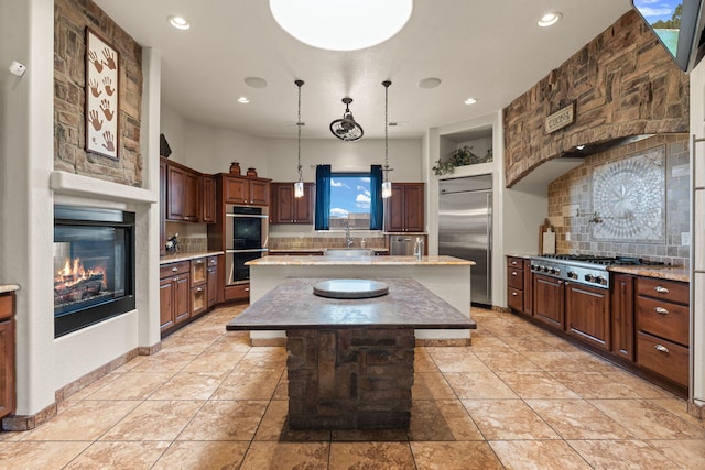 kitchen featuring stainless steel appliances, a kitchen island, hanging light fixtures, and decorative backsplash