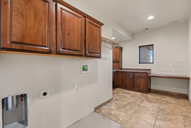 laundry area featuring electric dryer hookup, hookup for a washing machine, and cabinets