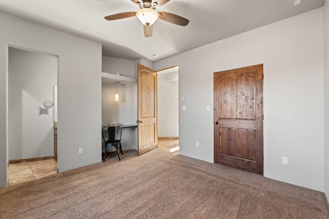 unfurnished bedroom featuring light colored carpet and ceiling fan