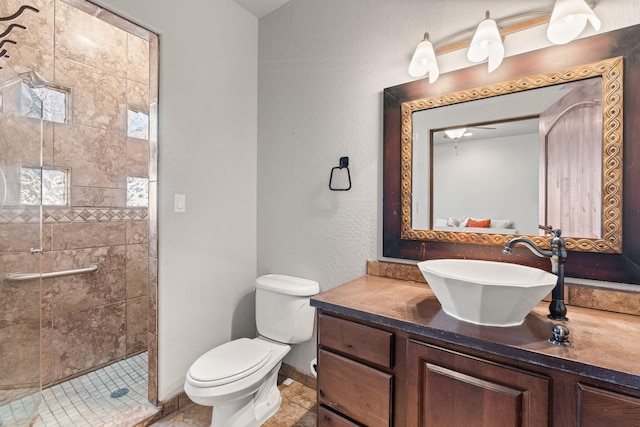 bathroom with vanity, toilet, and tiled shower