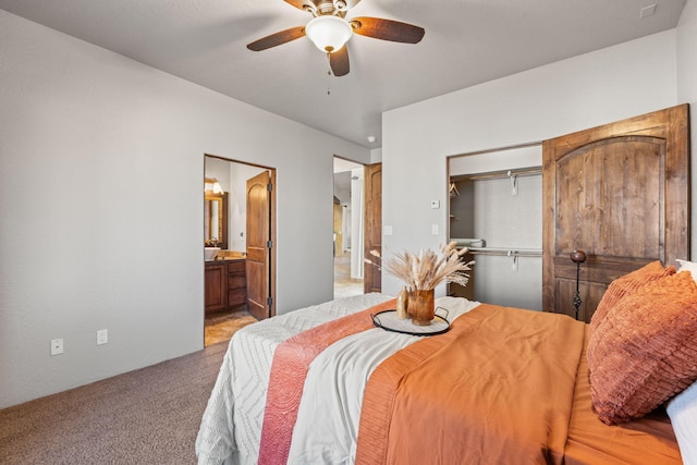 bedroom with connected bathroom, light colored carpet, ceiling fan, and a closet