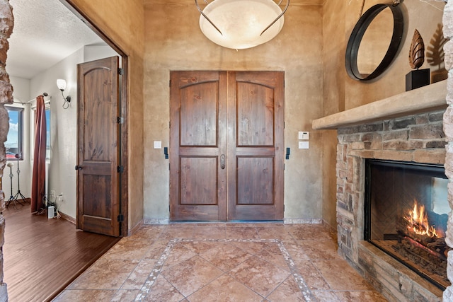 entrance foyer featuring a fireplace and a textured ceiling