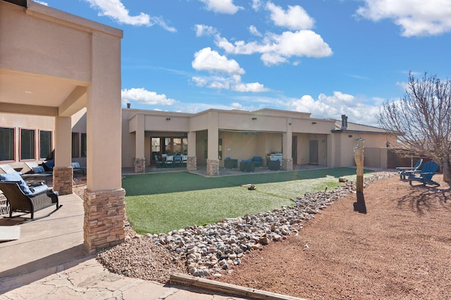 back of house with an outdoor living space and a patio area