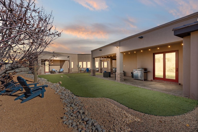 yard at dusk featuring a patio