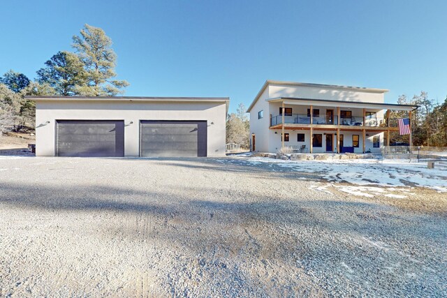 view of front facade with a balcony, a garage, and stucco siding